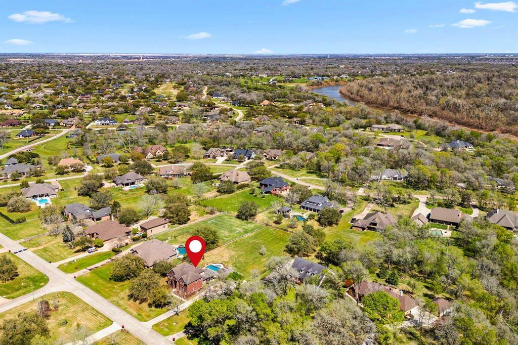 This view looks north/east from the property, offering a glimpse of the Brazos River in the distance, adding to the scenic beauty and tranquil setting of this home.