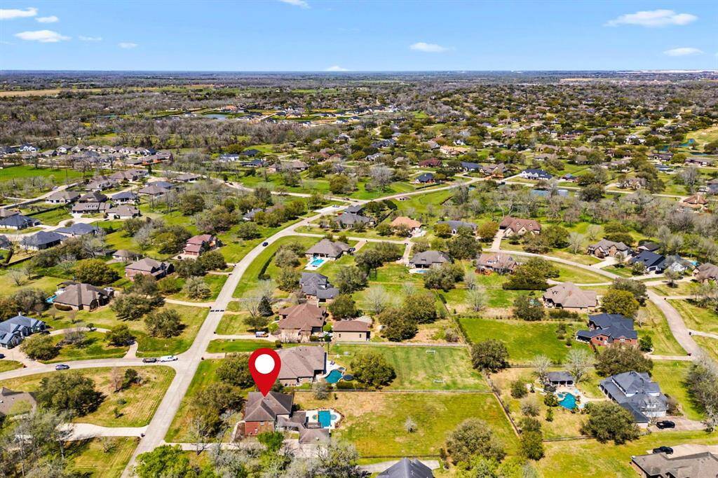 This view looks north, showcasing the surrounding neighborhood with its lush trees and expansive lots, highlighting the beauty and serenity of the area.