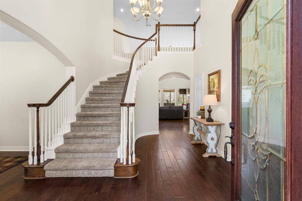As you enter, you are welcomed by stunning wood floors, a soaring 20-foot ceiling in the Foyer, an elegant staircase, and breathtaking views that stretch as far as the eye can see.