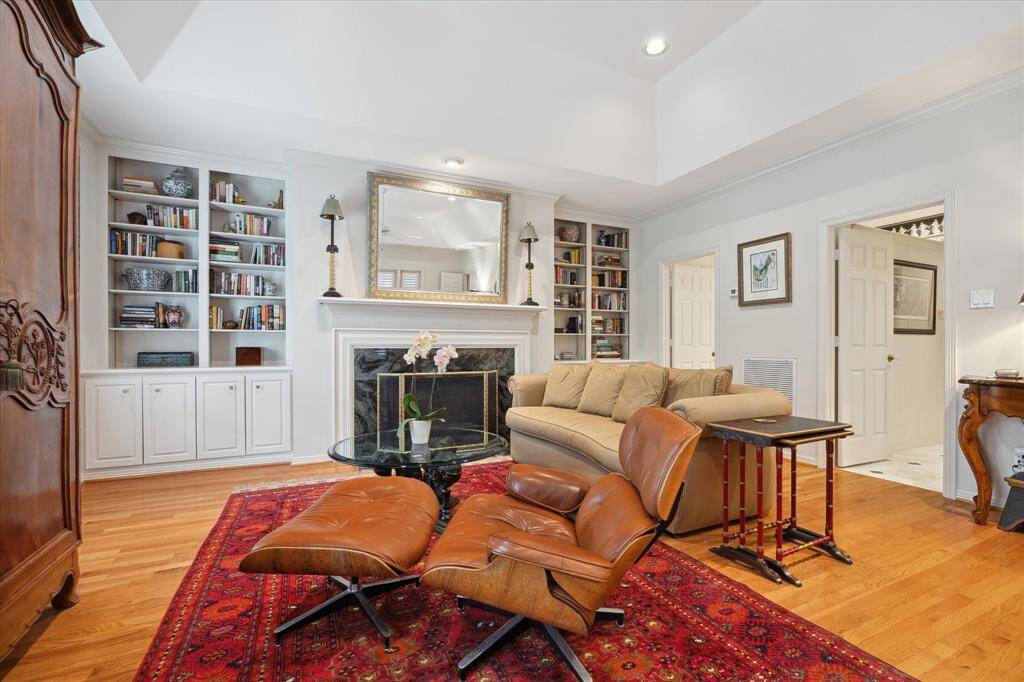 A close-up view of seller’s TV area close to the fireplace leading to the one of the two bathroom/closet suites.