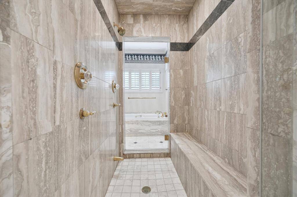 A large travertine shower connects the two primary bathrooms. Peek-a-boo!