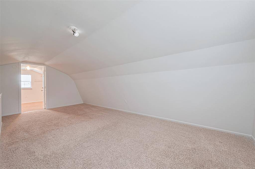 Upstairs flex space with cozy carpet and sloped ceilings—ideal for a private retreat, hobby room, or extra bedroom.