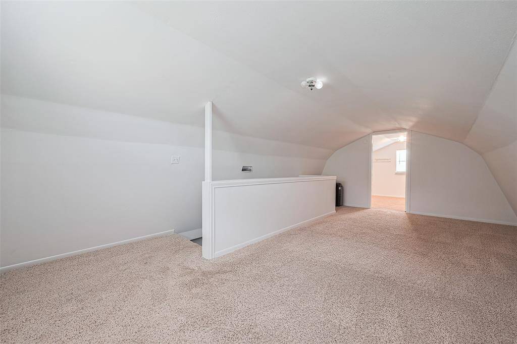 Charming upstairs loft with soft carpet, sloped ceilings, and a cozy nook feel—perfect for a reading area, home office, or creative space.