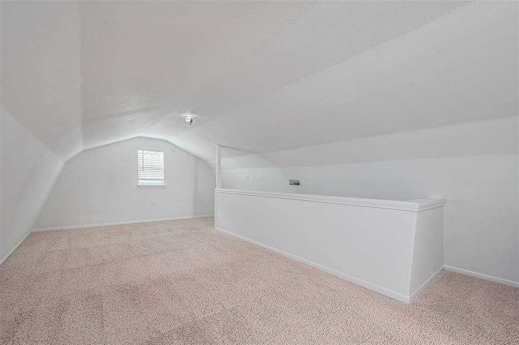 Bright and spacious upstairs loft with plush carpeting, natural light, and cozy sloped ceilings—ideal for a playroom, media space, or guest retreat.