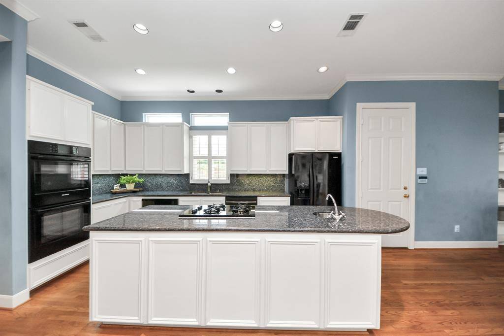 The chef-inspired kitchen centers around a striking island, surrounded by extensive cabinetry offering exceptional storage and function.