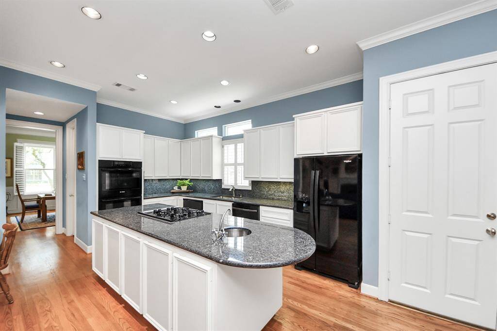 Showcases double oven, an impressive center island with a bar sink.