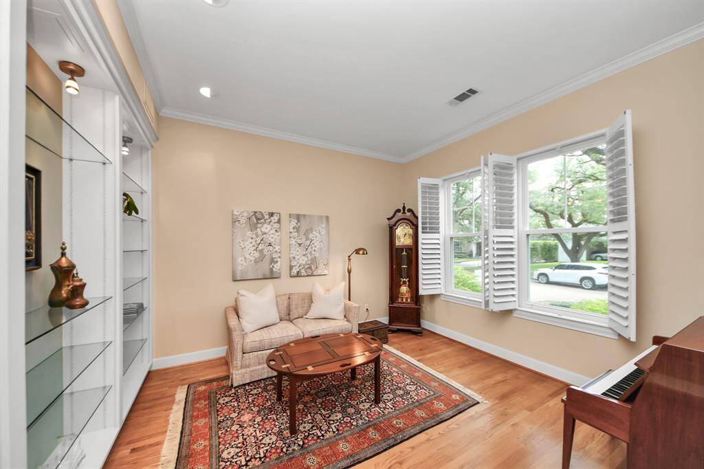 A stunning sitting room bathed in natural light, featuring wall-to-wall built-ins—perfect for a library, study, or tranquil escape.