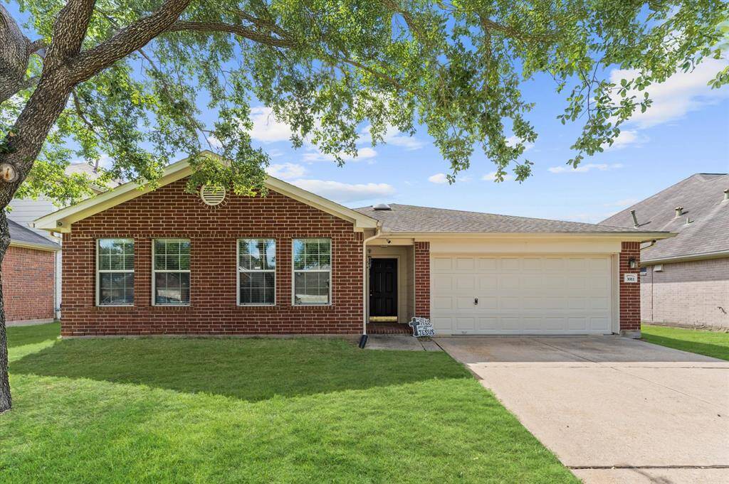 This charming home features a classic red brick exterior, a two-car garage, and a well-maintained front lawn with a mature tree providing shade. Perfect for a cozy family living.