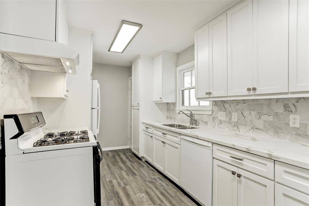 Remodeled Kitchen boasts marble counters & backsplash, wood flooring, new crisp cabinets & drawers, stainless undermount sink, terrific back access door offering worlds of light in the Bright & Cheerful Kitchen! NICE