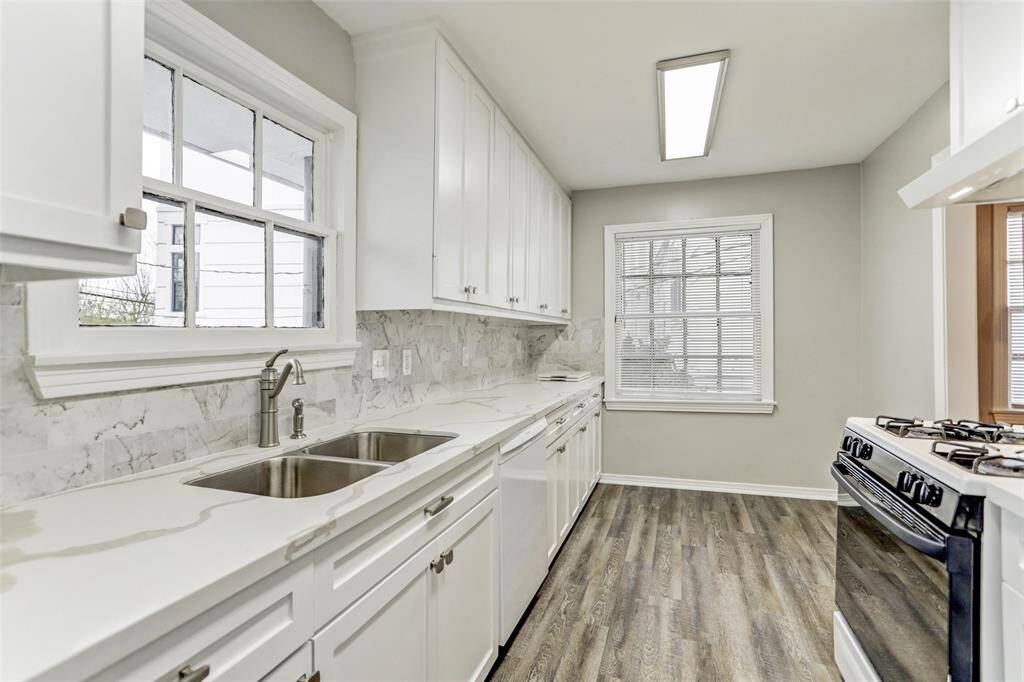 Recently renovated Kitchen boasts marble counters & backsplash, wood flooring, new crisp cabinets & drawers, stainless undermount sink, terrific back access door and sparkling windows offering worlds of natural light into the Bright & Cheerful Kitchen! NICE
