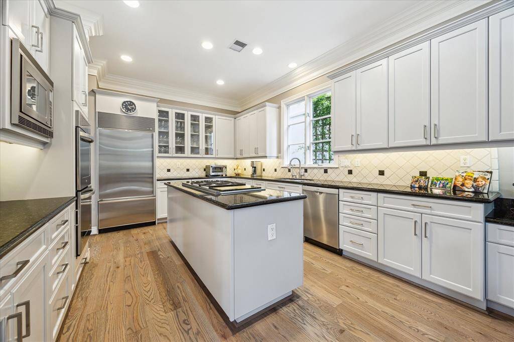 kitchen island with granite and gas coooktop. Double ovens and SubZero. Great storage space