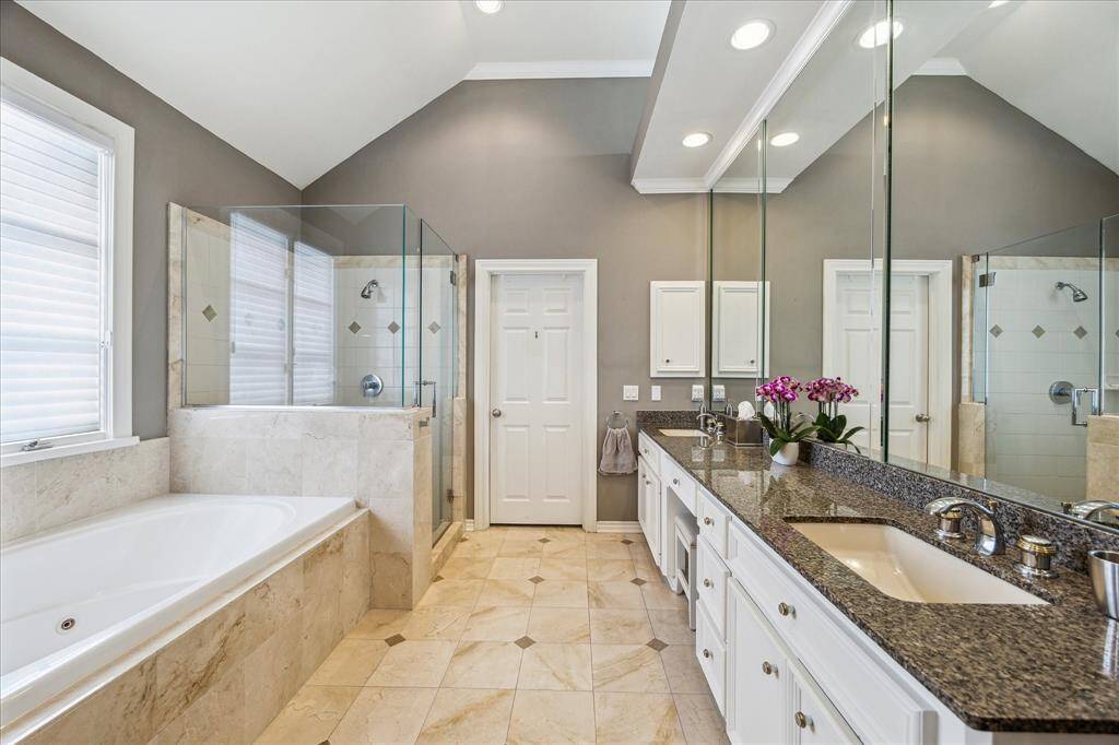 Primary bathroom with 2 sinks and whirlpool tub and separate shower.