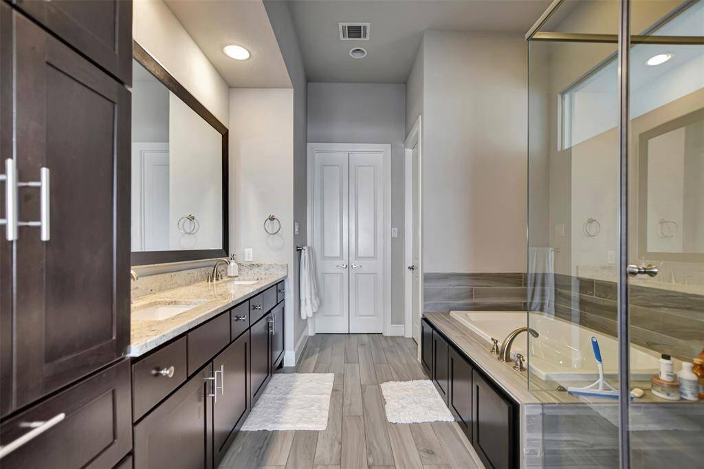 Amazing primary bathroom. Double sinks, lots of cabinets, separate tub and shower with large walking closet at the end.