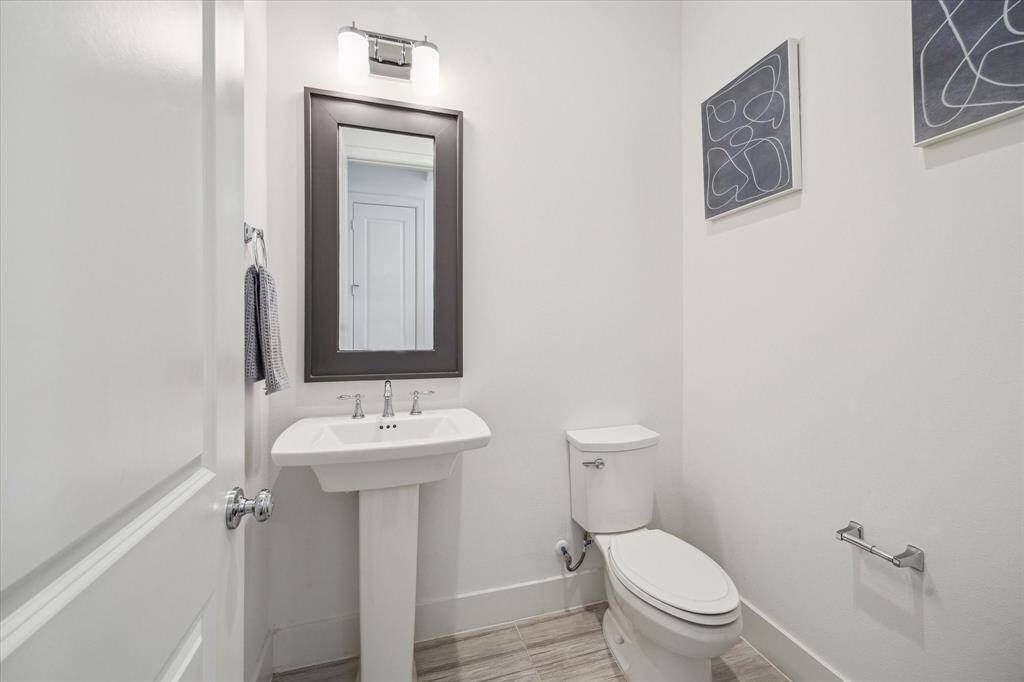 The Powder Room is tucked away at the front of the 1st floor next to the garage. As seen through the reflection in the mirror, is another storage closet on the 1st floor.