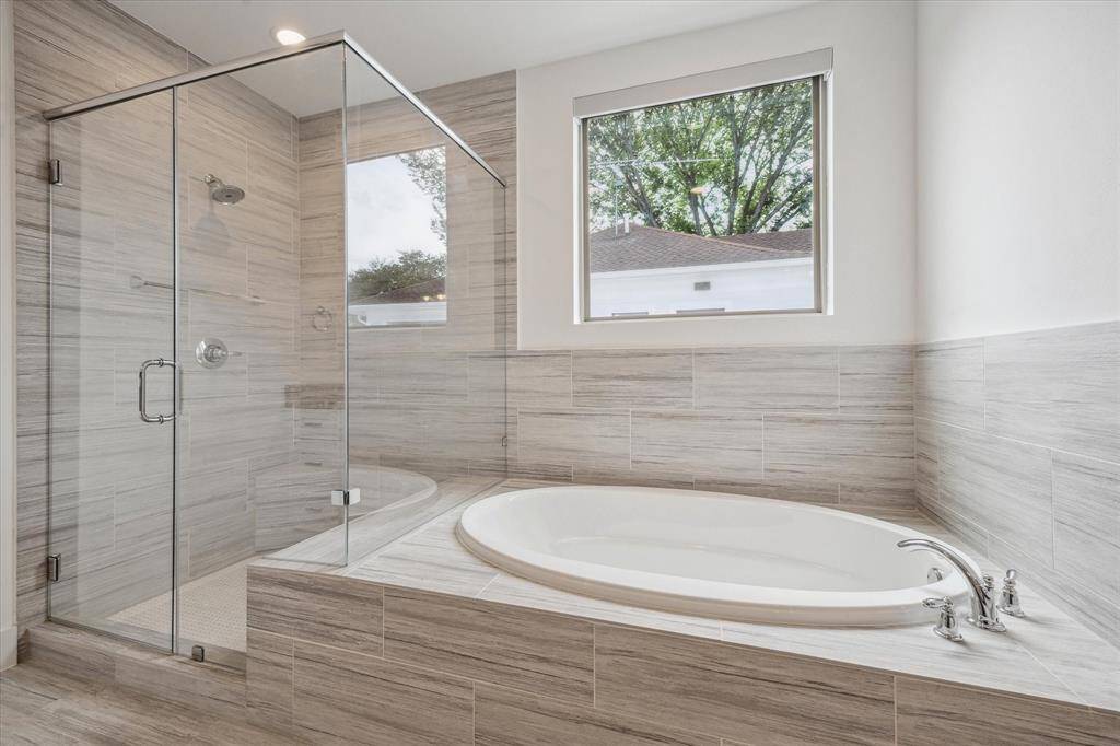 Stand up, glass-enclosed shower (with a seat) & soaking tub.