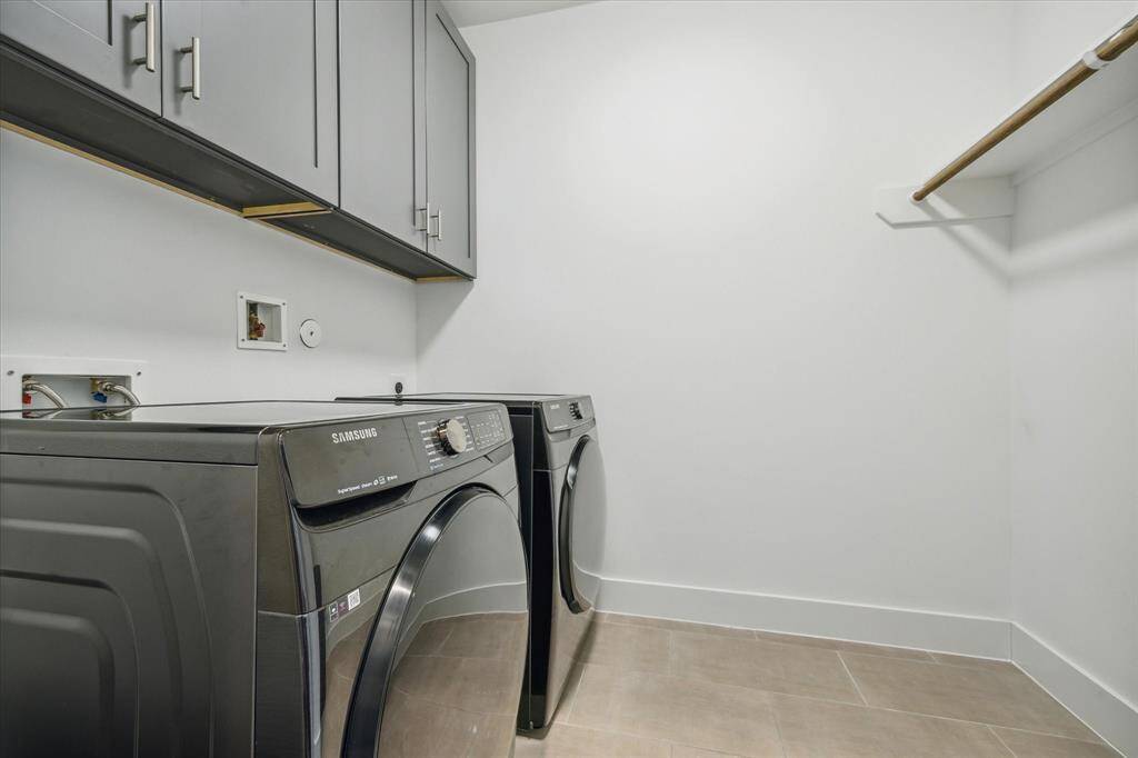 Upper-level Utility Room with storage shelves, a hanging rod and a side-by-side washer-dryer. Both STAY!