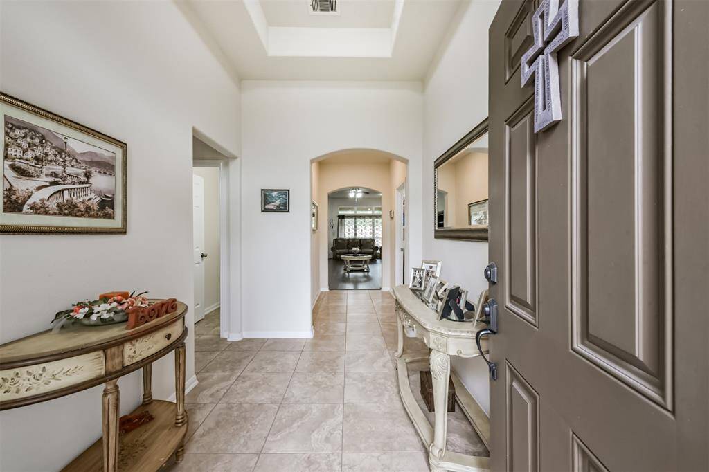 Enter through the front door to the welcoming foyer. Notice the arched doorway to the living room and detailed ceiling.