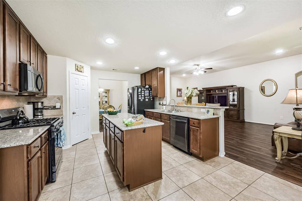 Kitchen has fabulous storage space, cabinets and island upgraded to hold additional storage. Walk-in pantry is in the corner of the kitchen leading to the formal dining room.