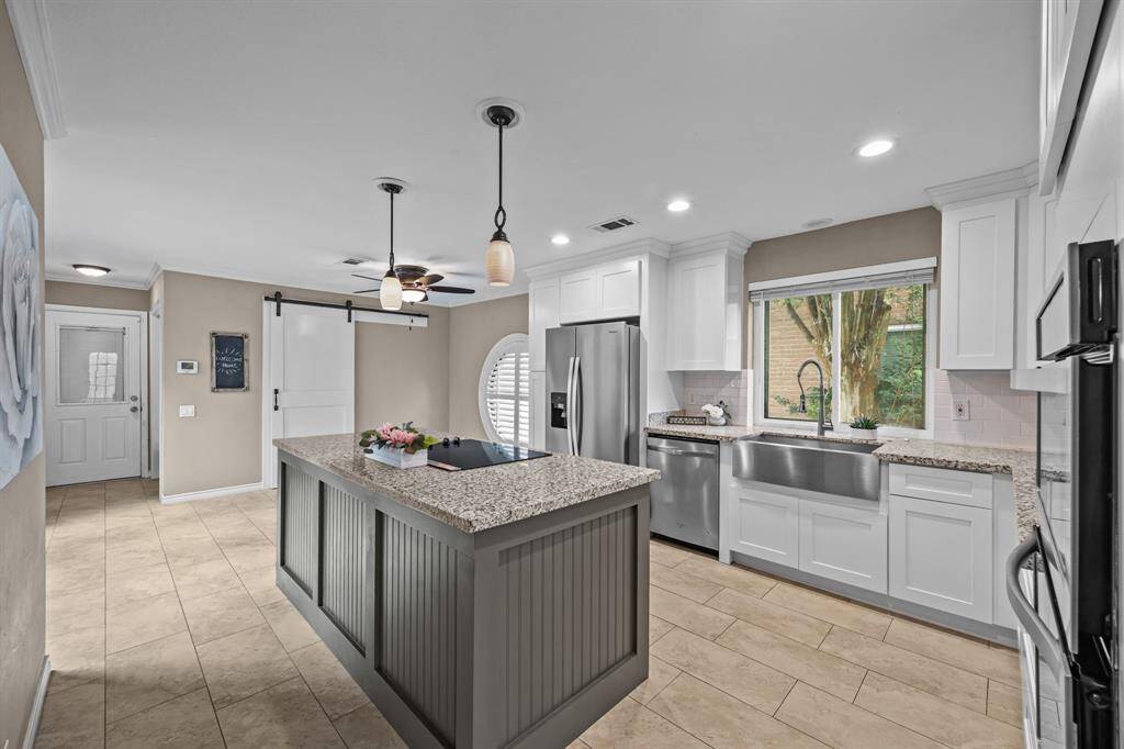 The kitchen is a dream with granite counters, stainless steel appliances, and a farmhouse sink.