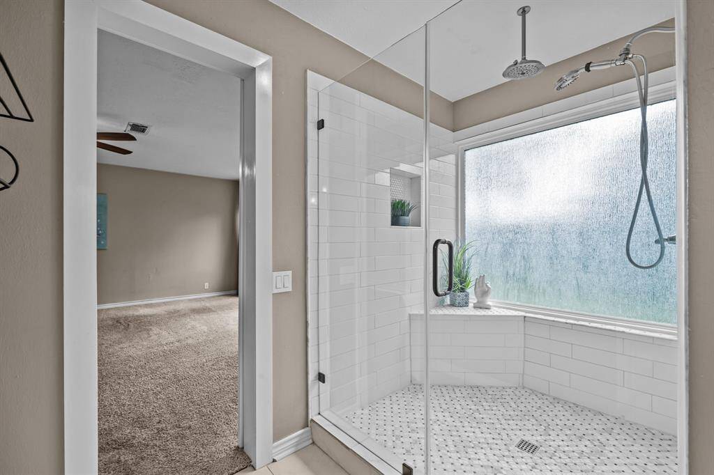 Experience luxury in this stunning walk-in shower, complete with elegant fixtures and a spacious design.