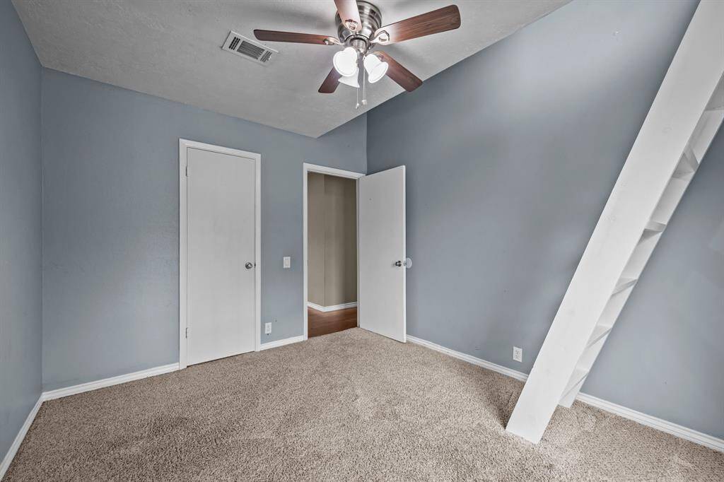 Cozy fourth bedroom with soft carpeting and a ceiling fan for comfort.