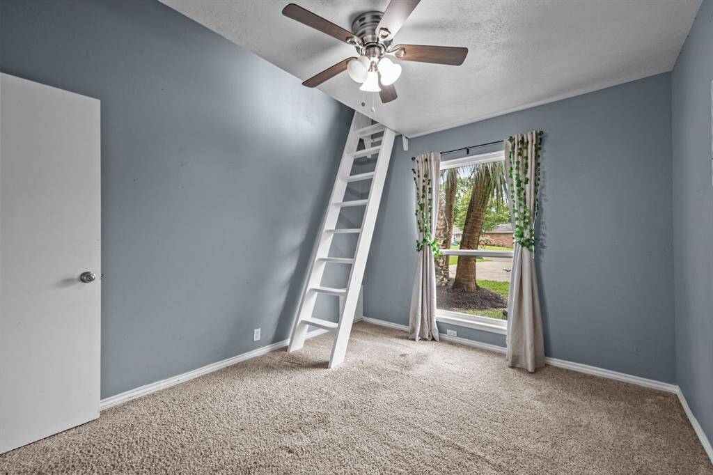 Cozy fourth bedroom with loft ladder and bright window views.