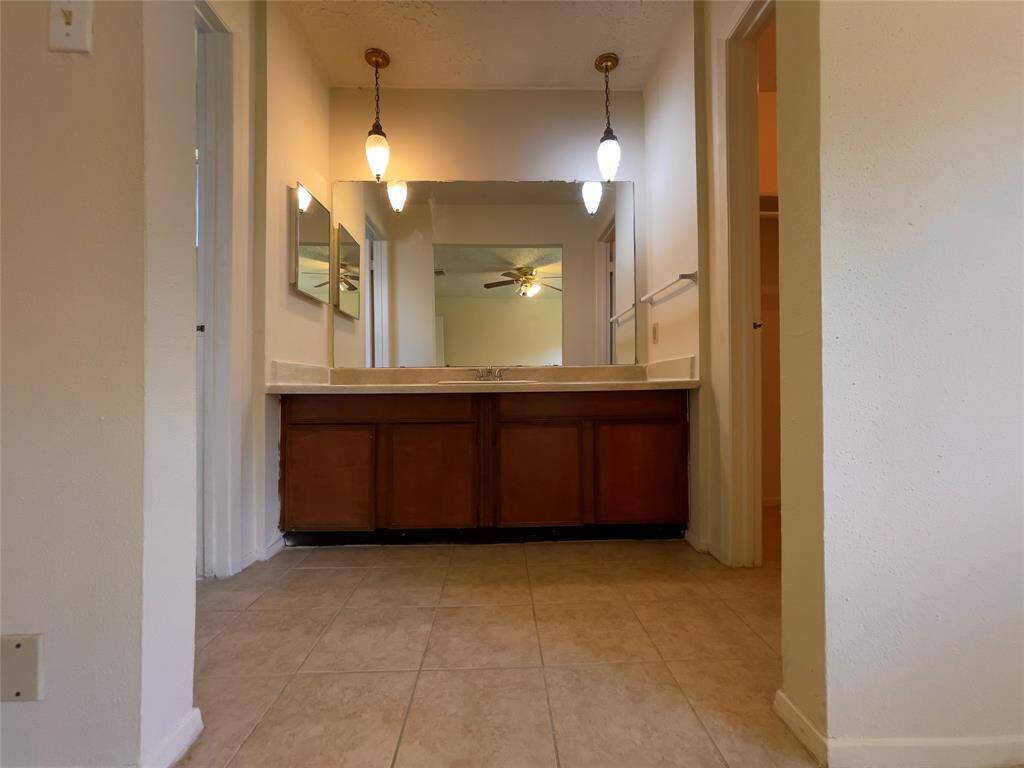 Primary vanity w/single sink. Shower and toilet to the left and closet to the right.