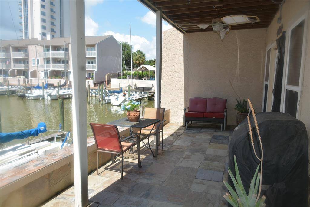Primary bedroom with double doors leading to private balcony overlooking marina and clear lake.