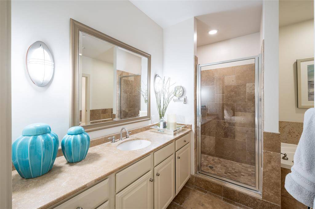 The primary suite's ensuite bath serves as a spa-like retreat, complete with a standalone shower and a tub