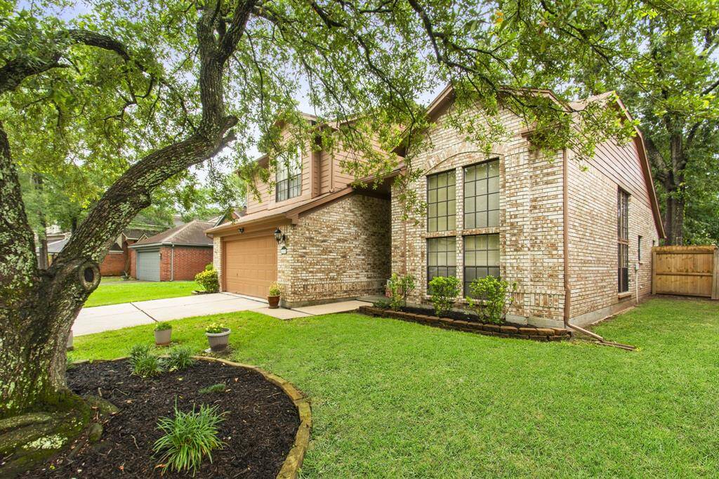 This charming home features a brick exterior with large windows, a two-car garage, and a well-maintained front yard with mature trees. Perfect for comfortable living in a peaceful neighborhood.