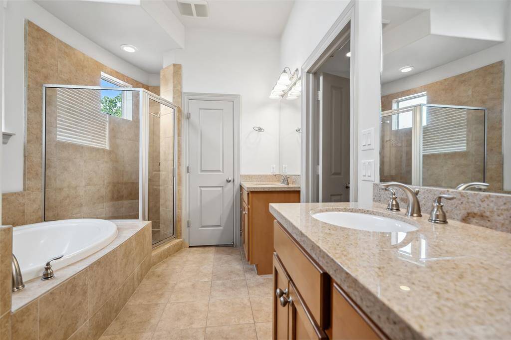 This spacious bedroom features a modern design with hardwood floors, a large window with curtains, a ceiling fan, and a stylish bed with a dark headboard. A sleek nightstand and a full-length mirror enhance the room's contemporary feel.