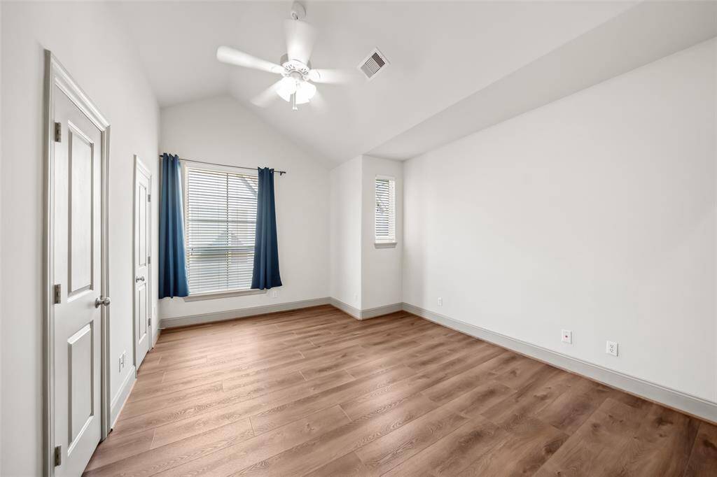 This inviting living room features hardwood floors, a cozy fireplace, and abundant natural light from large windows. It includes a built-in entertainment center, a comfortable sectional sofa, and modern decor, creating a warm and stylish atmosphere.