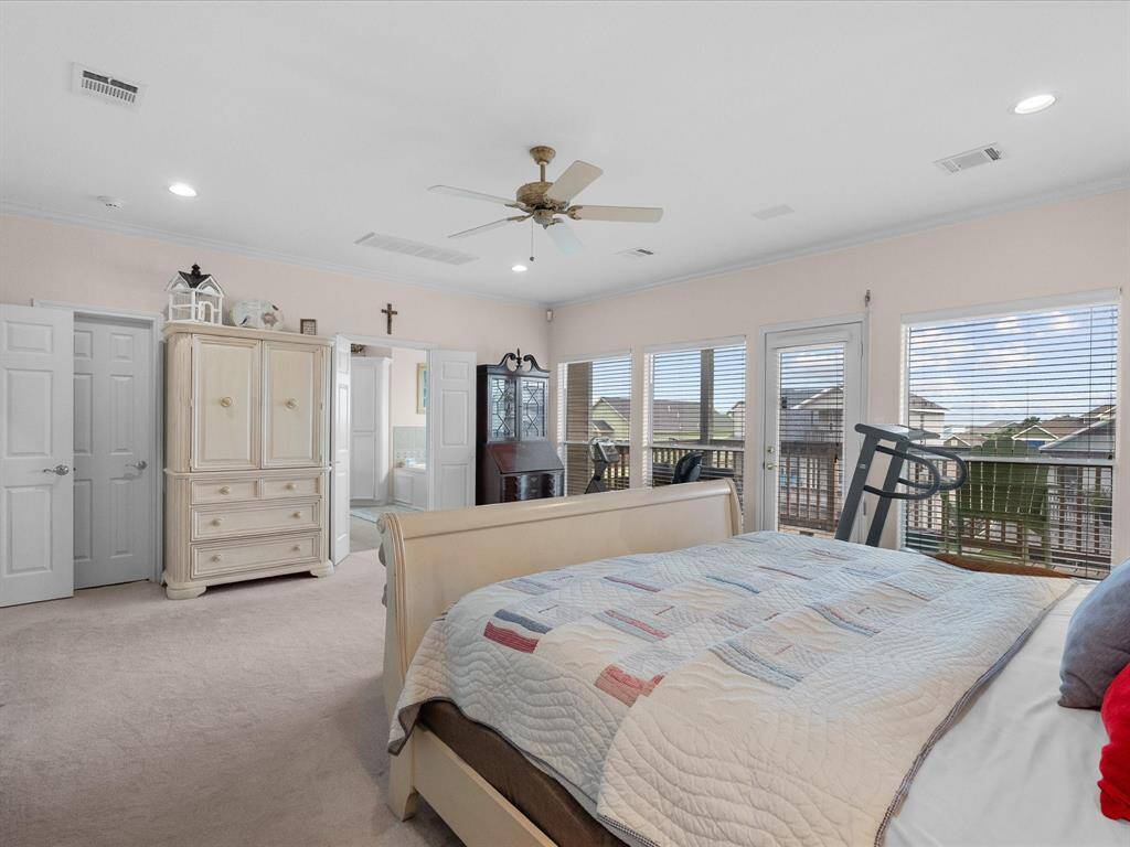 The primary bedroom features a ceiling fan, recessed lighting, and soft carpeting.