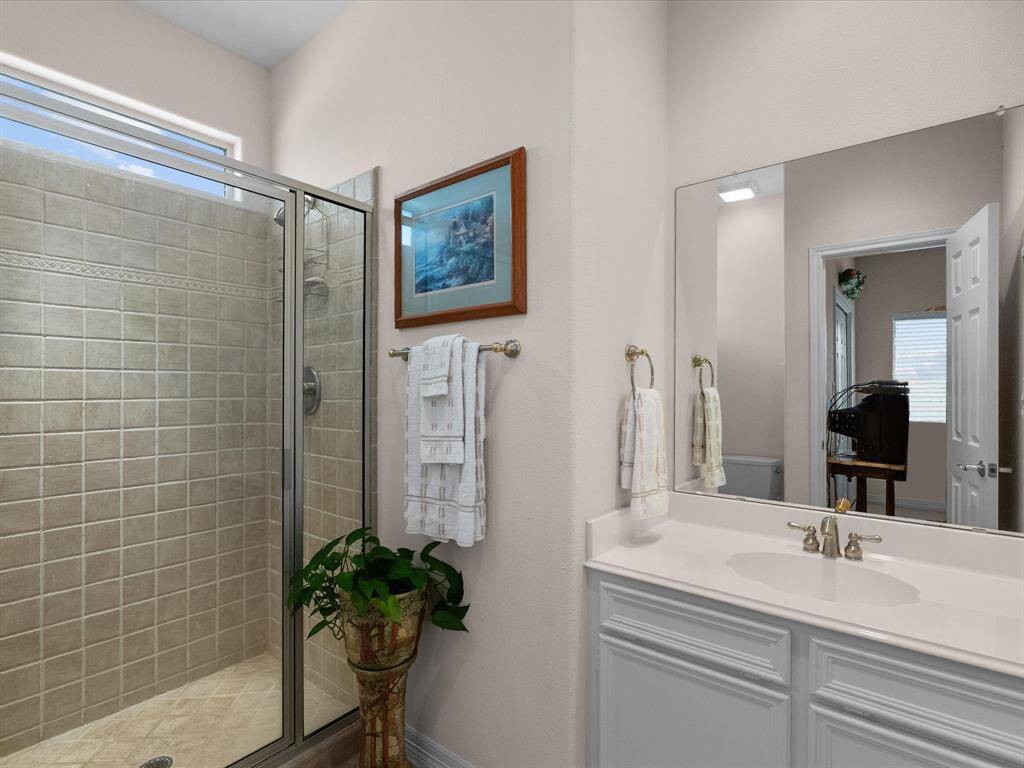 Upstairs bedroom 2 features its own en-suite bathroom, equipped with a spacious walk-in shower that is fully tiled with a clear glass enclosure, offering a sleek and modern look.