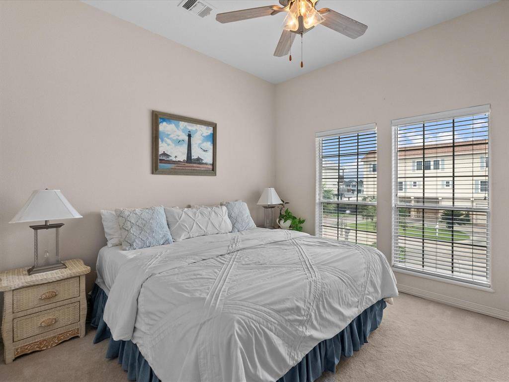 This main level  bedroom features  ample natural light from two large front windows, offering views of the neighborhood.