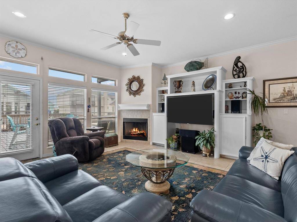 Large windows and a glass door leading to the outdoor space fill the room with natural light.