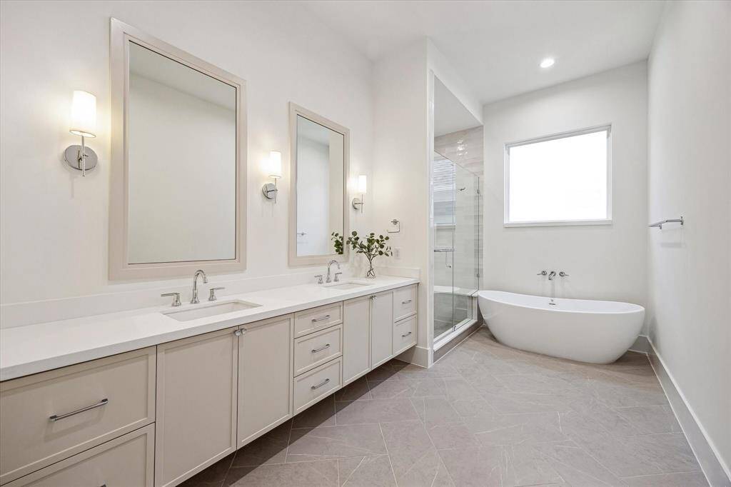A primary bath retreat with dual sinks, custom tile work and soaking tub.