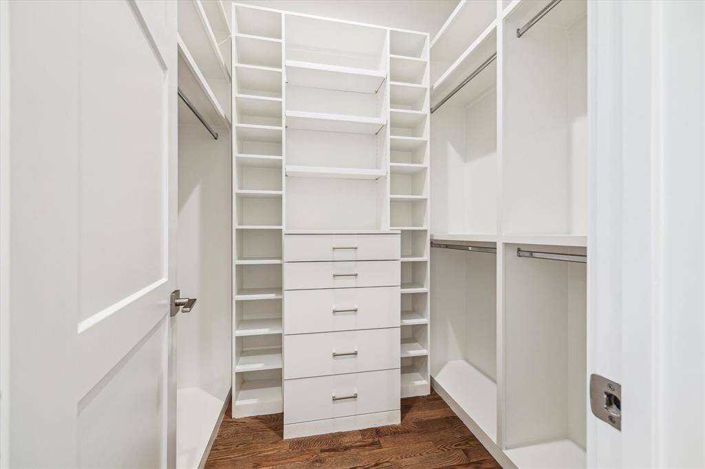 Dual primary closets with built in shelving and drawers.