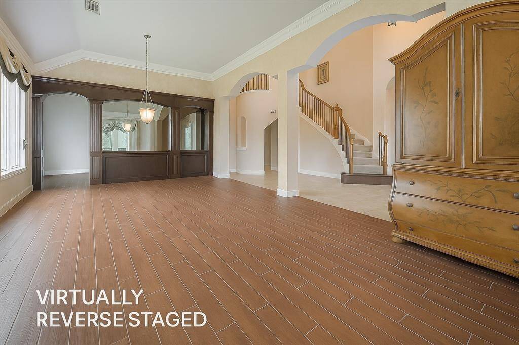Notice the tall arched openings leading into the combined formal dining and living room.