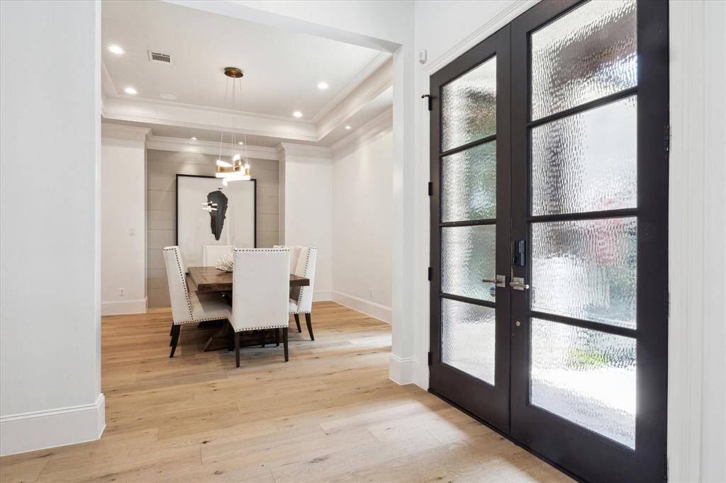 The front doors are a set of sleek, textured glass double doors, enhancing natural light and providing a contemporary touch.