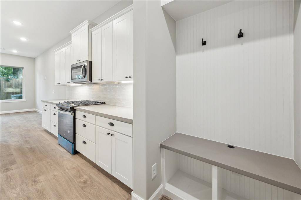 A built-in drop zone with hooks and a bench keeps clutter at bay—perfect for bags, coats, and daily essentials.