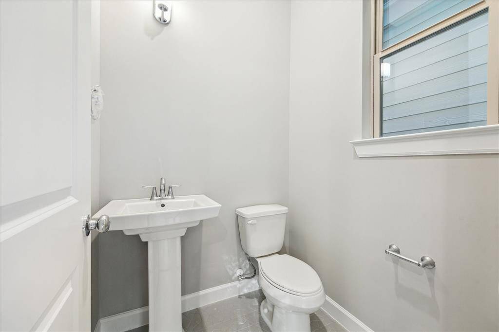 A bright, simple half-bath with pedestal sink—ideal for guests and smartly tucked on the main level.