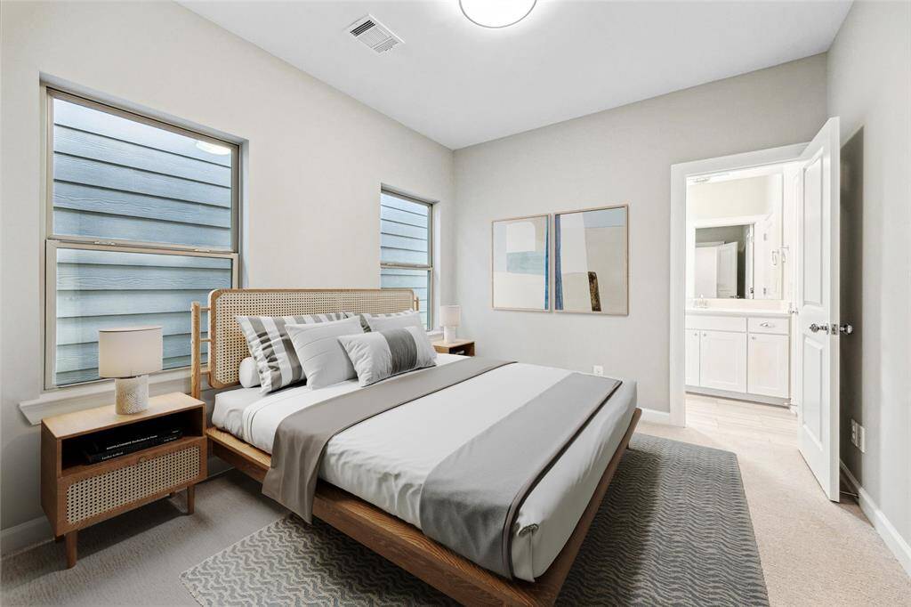 Secondary bedroom with en suite bath access and large windows for natural light.