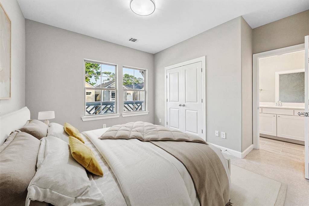 Secondary bedroom with en suite bath access and large windows for natural light.