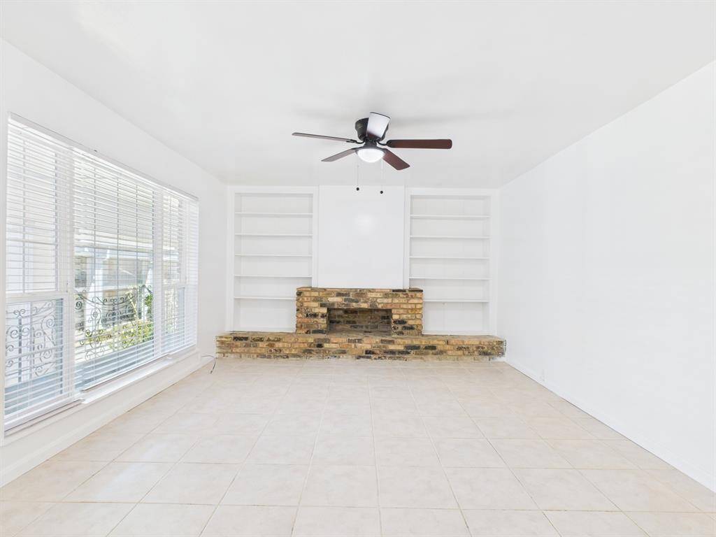 Spacious Living Area with Exposed Brick Faux Fireplace & Built-in Shelving