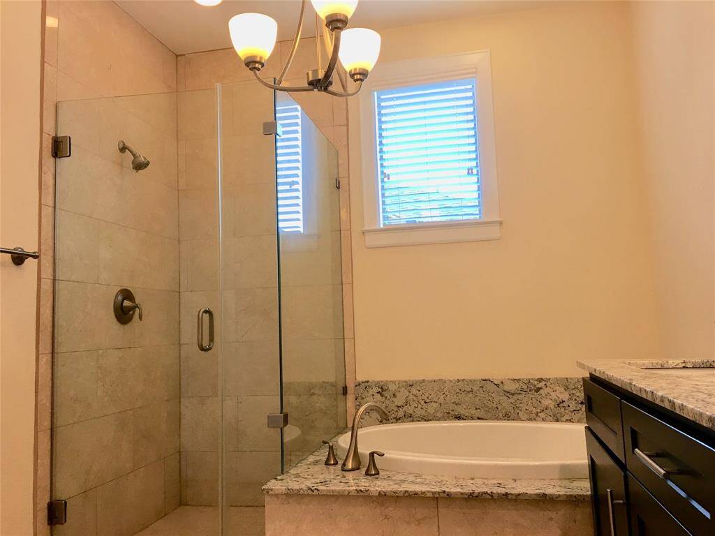 Master bath room with shower, tub and chandelier lighting