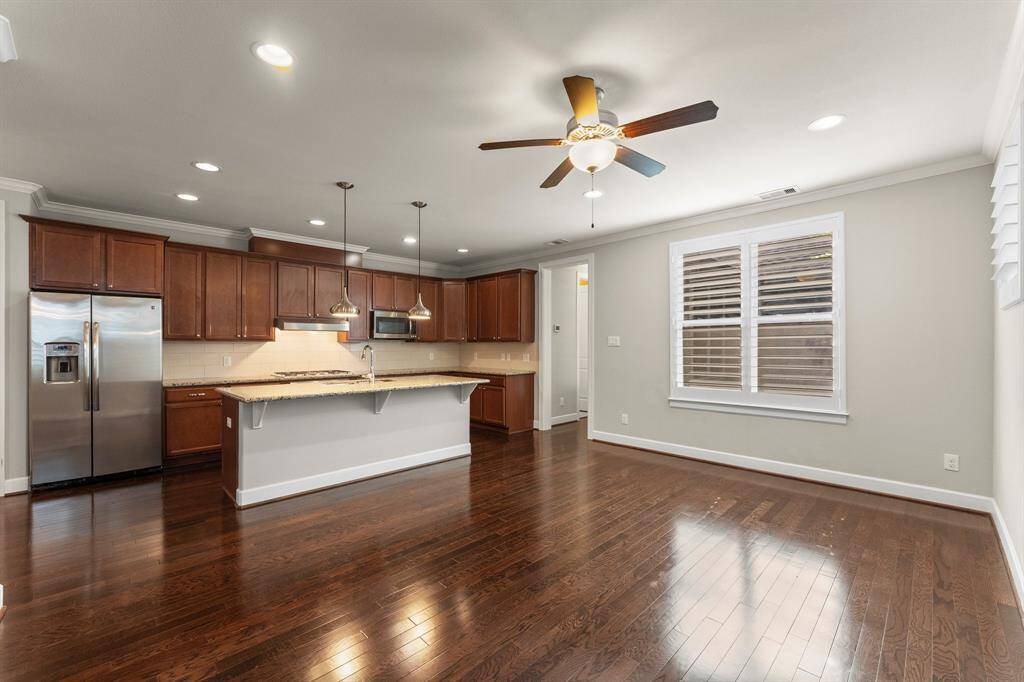 This spacious kitchen and breakfast area features granite countertops, stainless steel appliances, rich wood cabinetry, and an open layout ideal for entertaining.