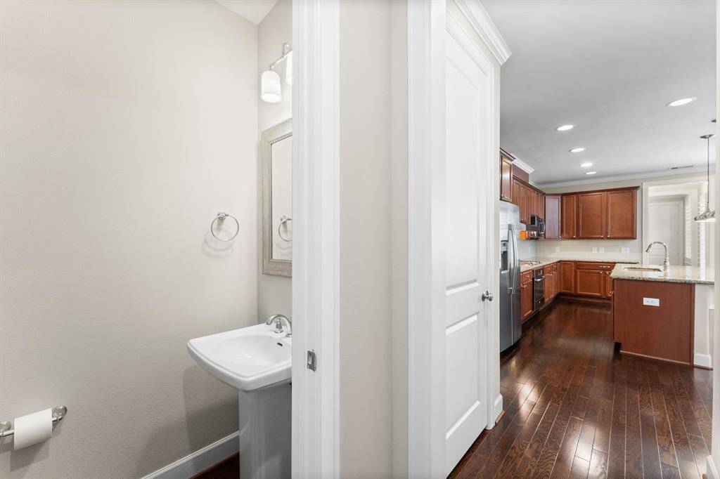 This view highlights a convenient half bath located just off the kitchen, ideal for guests and everyday living.