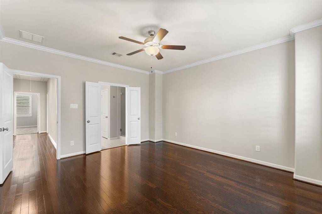 The primary suite offers elegant hardwood flooring, crown molding, and direct access to a spacious ensuite bath.