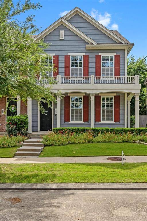 Beautifully maintained two-story home featuring vibrant red shutters, dual covered porches, and charming curb appeal in a desirable neighborhood setting.